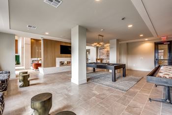 Resident clubhouse with fireplace, billiards table, shuffleboard, and full-service coffee bar
